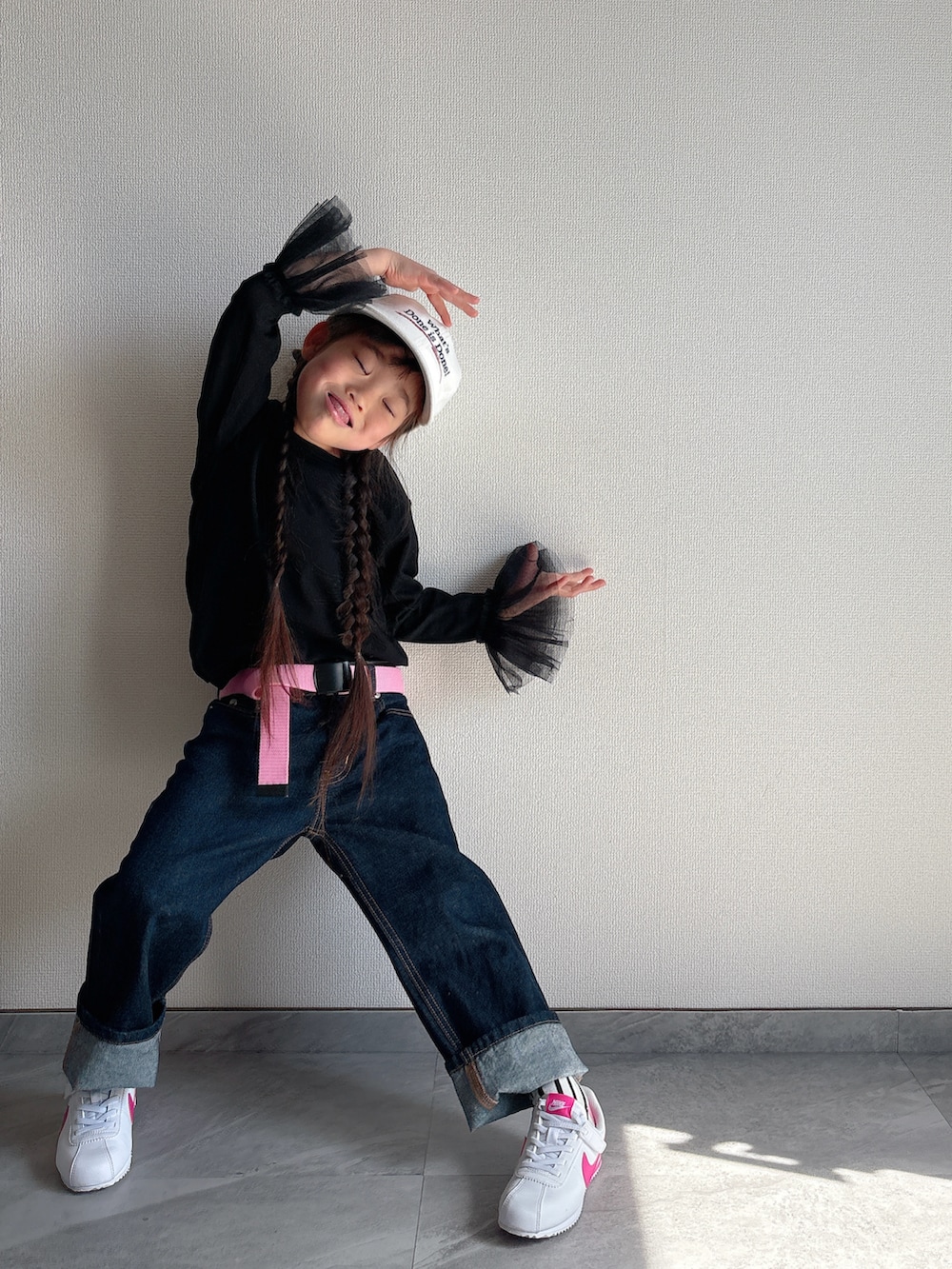 ブラック系のTシャツ/カットソー、ブルー系のデニムパンツ、ホワイト系のスニーカーを着用したキッズの春コーディネートの2枚目の写真