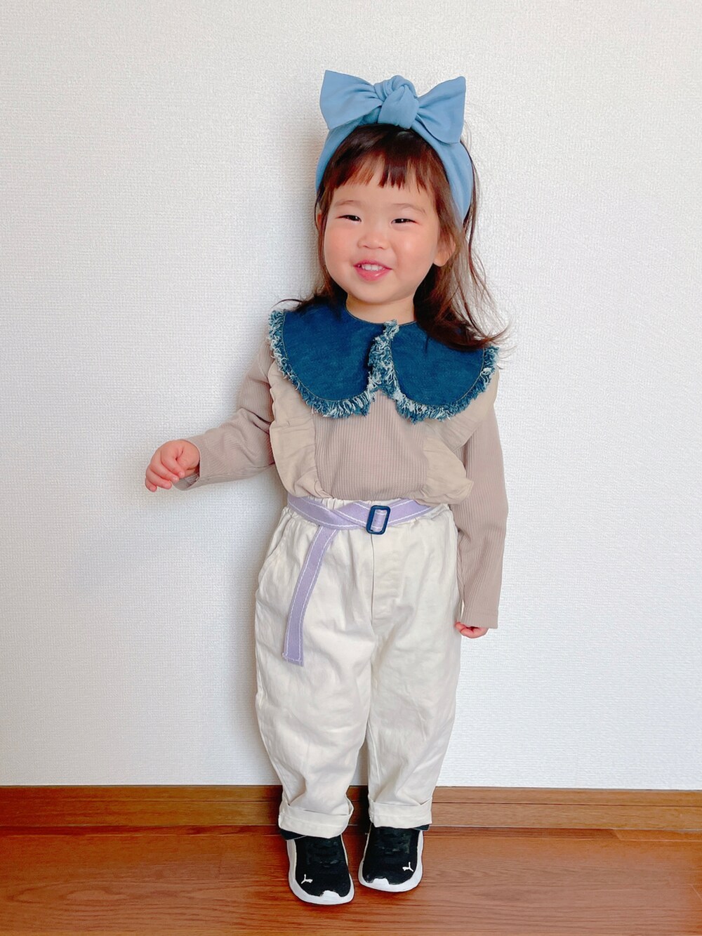 ホワイト系のパンツ、ブラック系のスニーカー、ベージュ系のTシャツ/カットソーを着用したキッズの春コーディネートの2枚目の写真