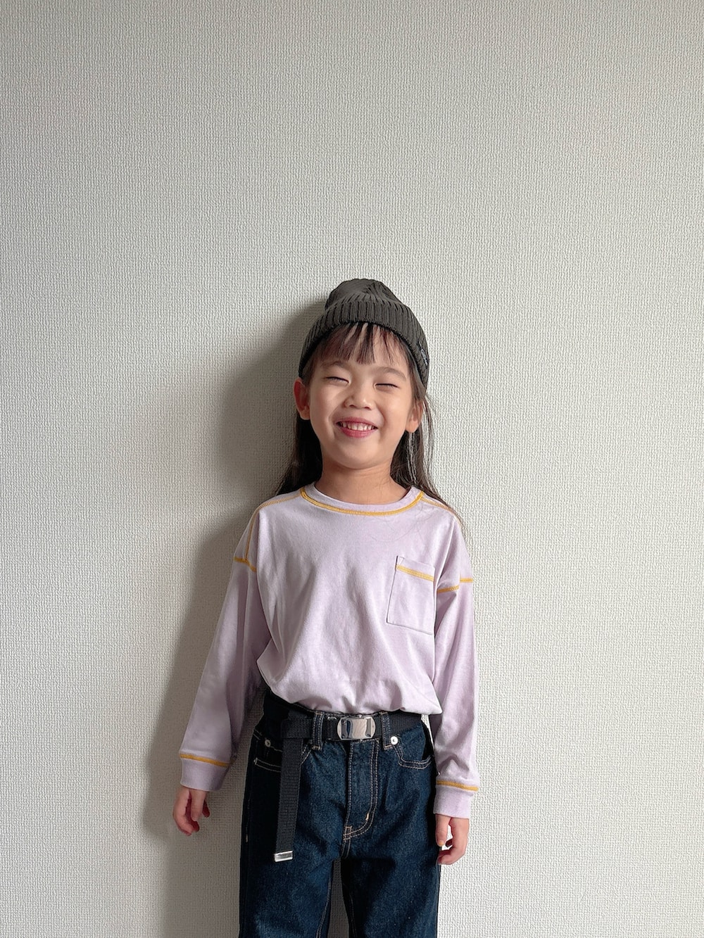 パープル系のTシャツ/カットソー、ブルー系のデニムパンツ、ブラック系のスニーカーを着用したキッズの秋コーディネートの4枚目の写真