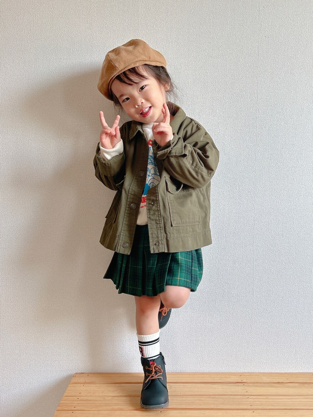 グリーン系のその他アウター、ホワイト系のスウェット、グリーン系のスカートを着用したキッズの秋コーディネートの2枚目の写真