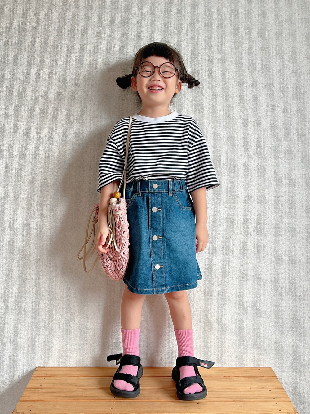 ピンク系のTシャツ/カットソー、ブルー系のデニムスカート、ピンク系のトートバッグを着用したキッズの夏コーディネートの2枚目の写真
