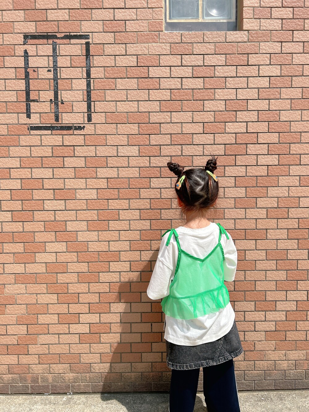 グリーン系のキャミソール、ホワイト系のTシャツ/カットソー、ブラック系のデニムスカートを着用したキッズの春コーディネートの5枚目の写真