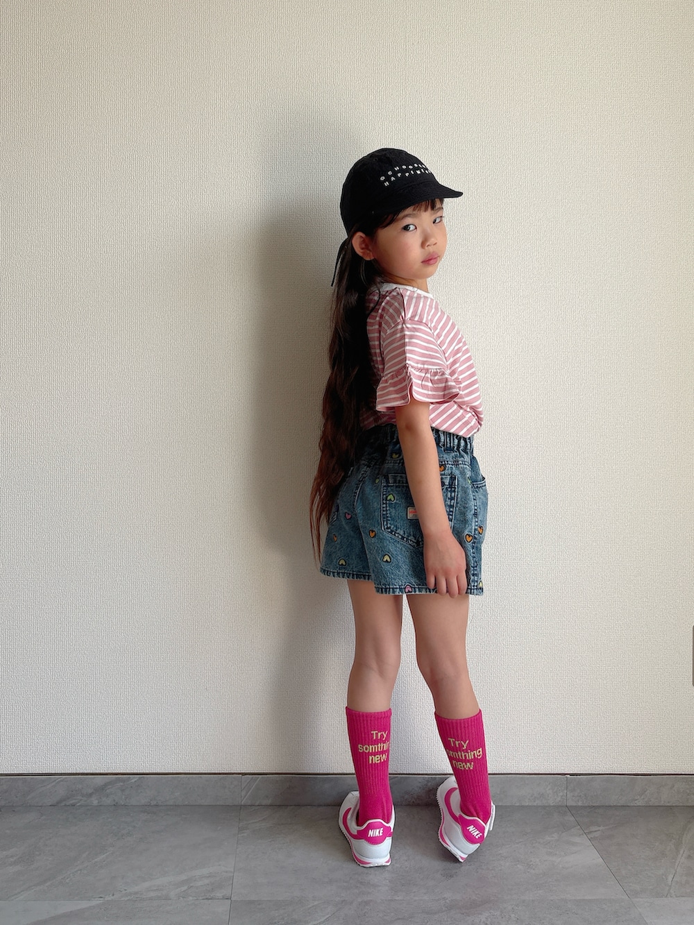 ピンク系のTシャツ/カットソー、ブルー系のデニムパンツ、ホワイト系のスニーカーを着用したキッズの春コーディネートの3枚目の写真