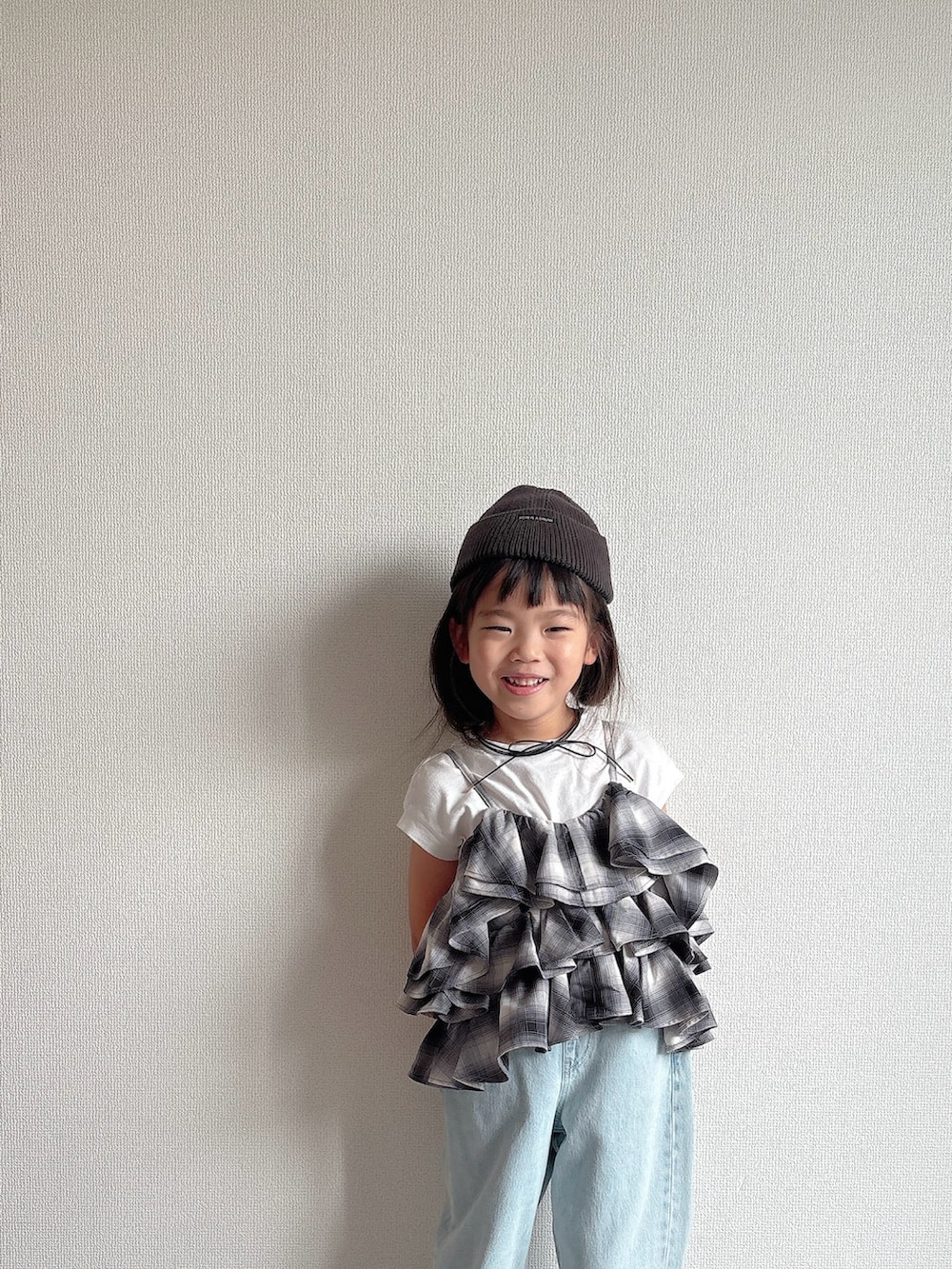 ブラック系のキャミソール、ブルー系のデニムパンツ、ブラック系のスニーカーを着用したキッズの夏コーディネートの3枚目の写真