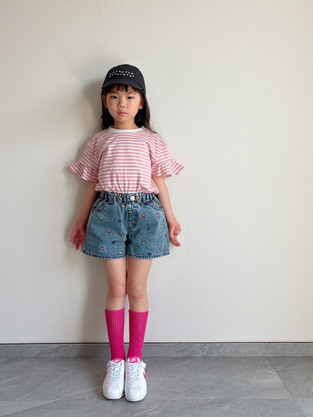 ピンク系のTシャツ/カットソー、ブルー系のデニムパンツ、ホワイト系のスニーカーを着用したキッズの春コーディネートの2枚目の写真