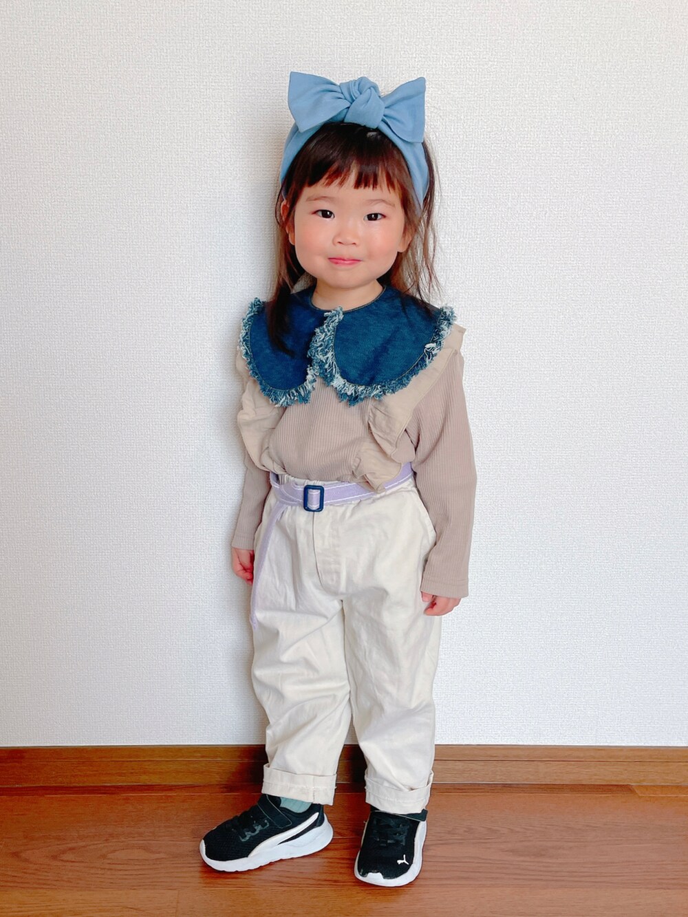 ホワイト系のパンツ、ブラック系のスニーカー、ベージュ系のTシャツ/カットソーを着用したキッズの春コーディネートの3枚目の写真