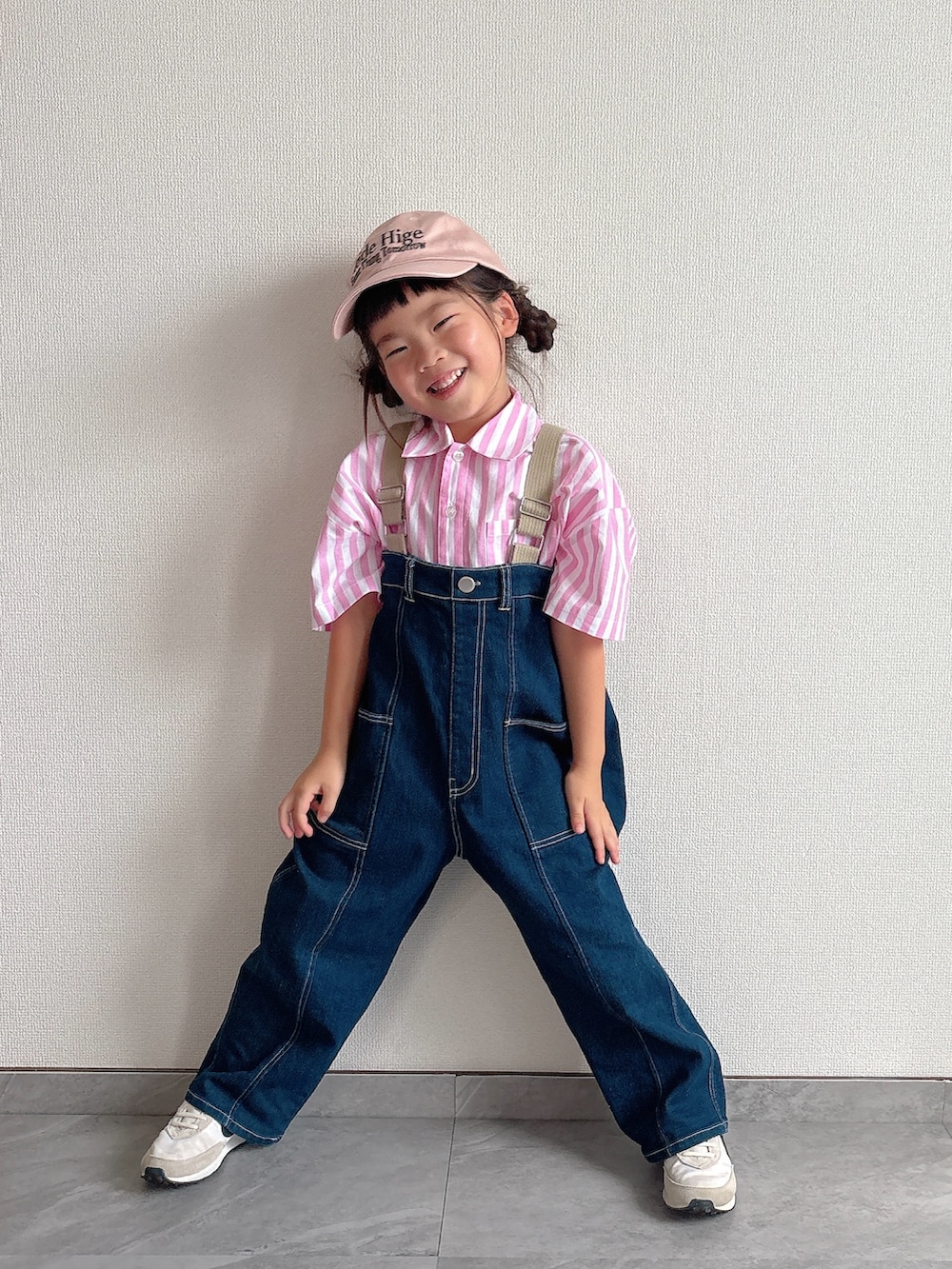 ピンク系のシャツ/ブラウス、ブルー系のサロペット/オーバーオール、ホワイト系のスニーカーを着用したキッズの夏コーディネートの2枚目の写真