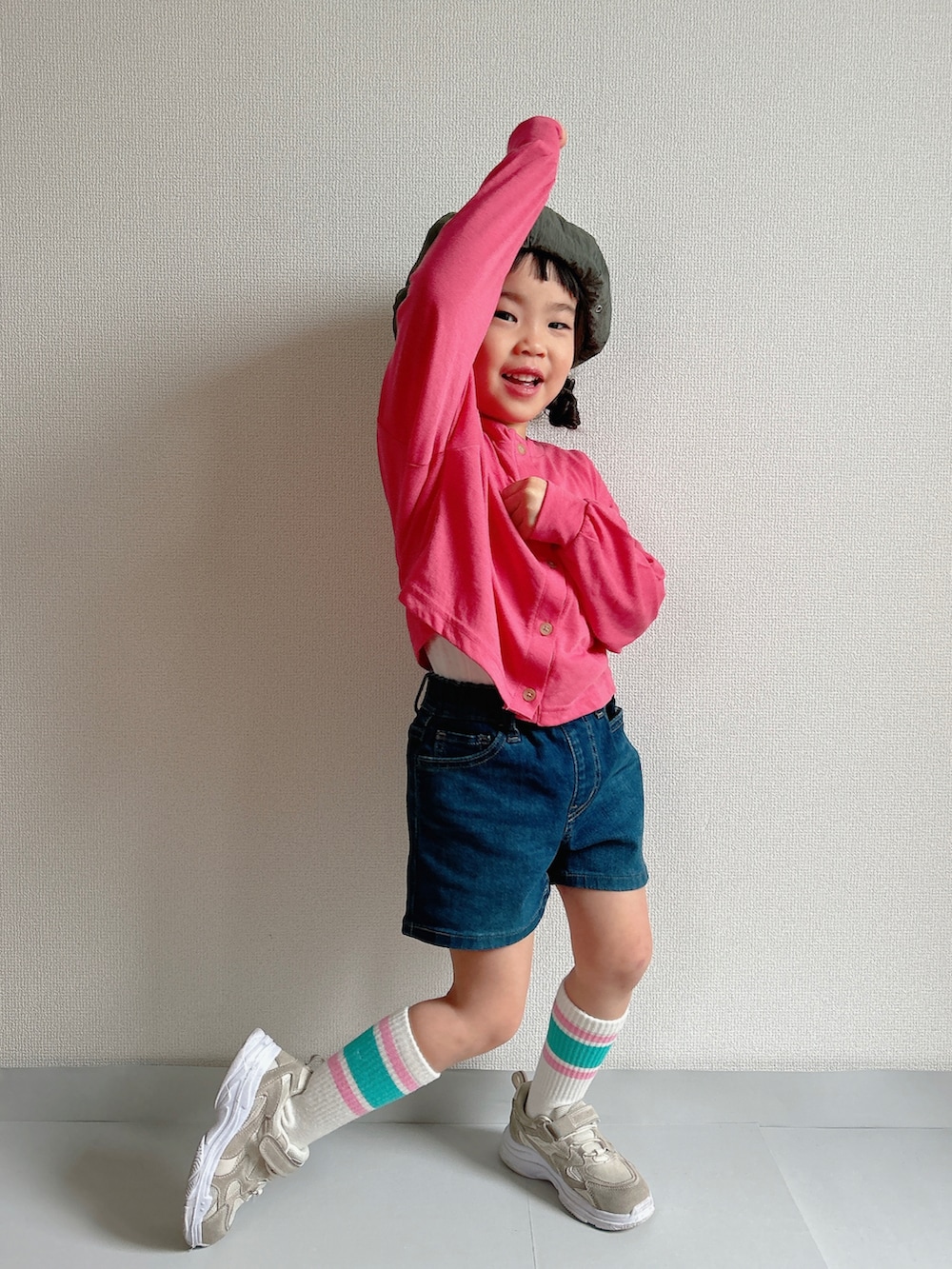 ピンク系のカーディガン/ボレロ、ブルー系のデニムパンツ、ベージュ系のスニーカーを着用したキッズの春コーディネートの4枚目の写真