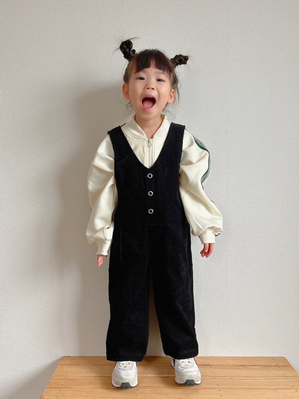 ホワイト系のブルゾン、ブラック系のつなぎ/オールインワン、ホワイト系のスニーカーを着用したキッズの冬コーディネートの2枚目の写真