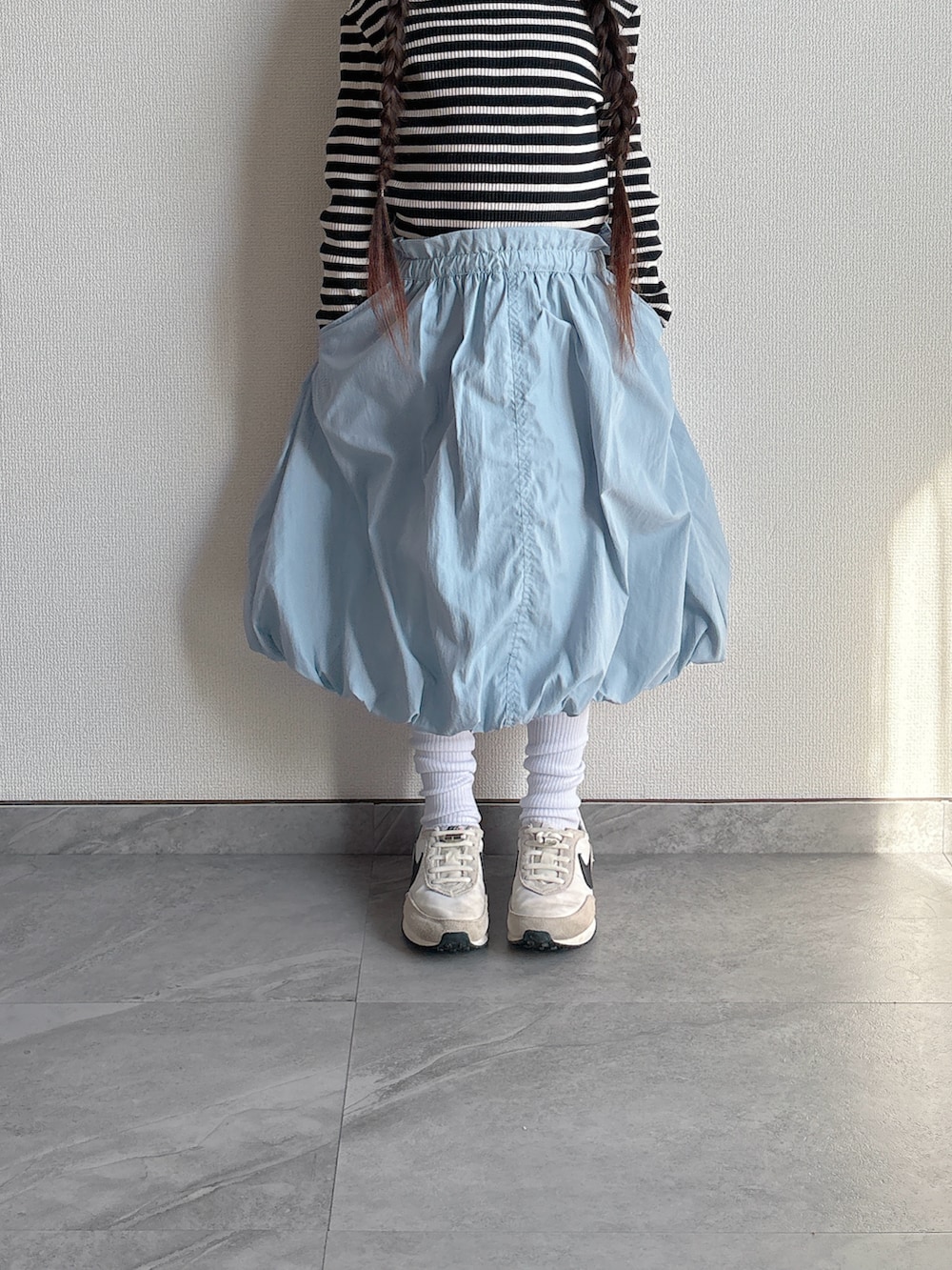 ブルー系のスカート、ホワイト系のスニーカーを着用したキッズの冬コーディネートの3枚目の写真