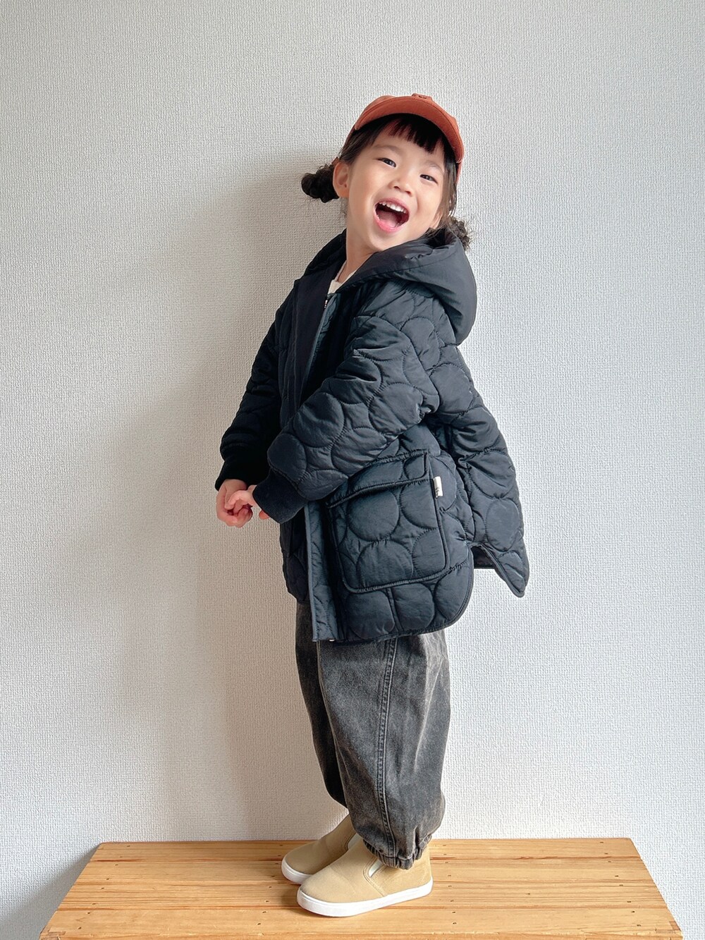 ブラック系のその他アウター、ホワイト系のニット/セーター、ブラック系のデニムパンツを着用したキッズの秋コーディネートの2枚目の写真