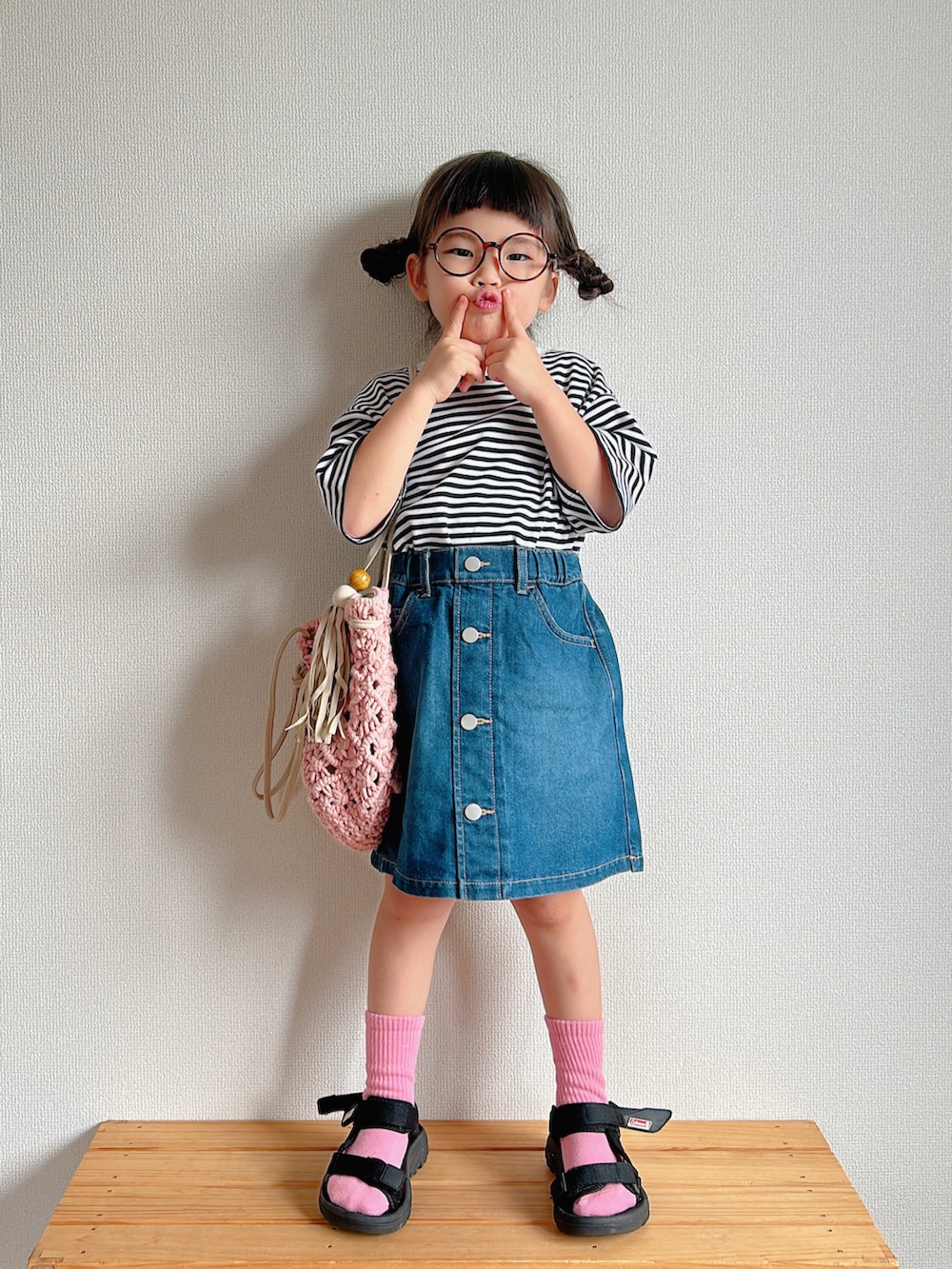 ピンク系のTシャツ/カットソー、ブルー系のデニムスカート、ピンク系のトートバッグを着用したキッズの夏コーディネートの3枚目の写真