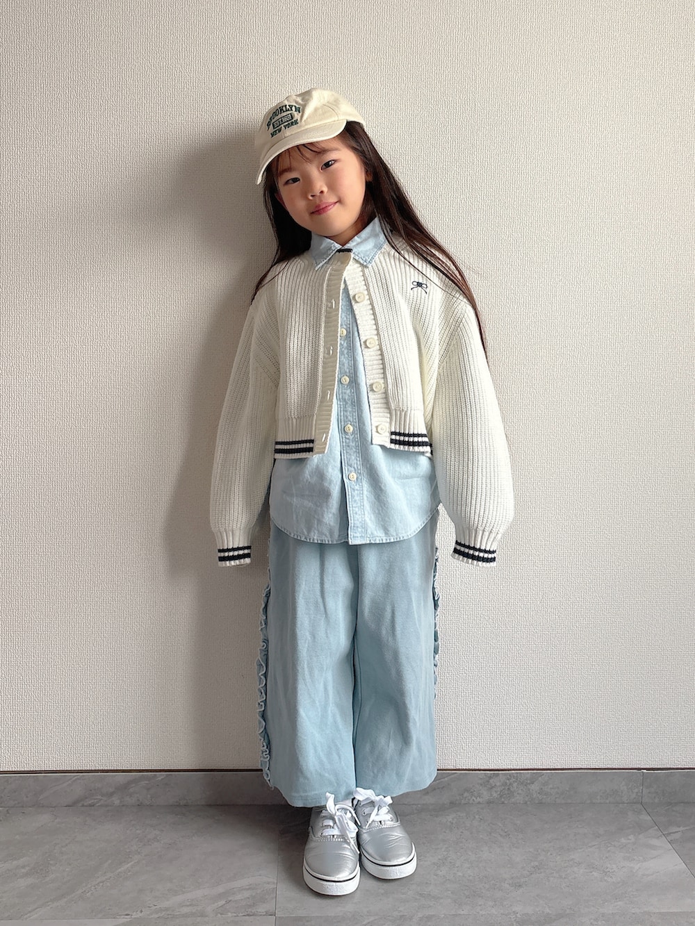 ブルー系のその他パンツ、ホワイト系のカーディガン/ボレロ、ブルー系のシャツ/ブラウスを着用したキッズの冬コーディネートの2枚目の写真