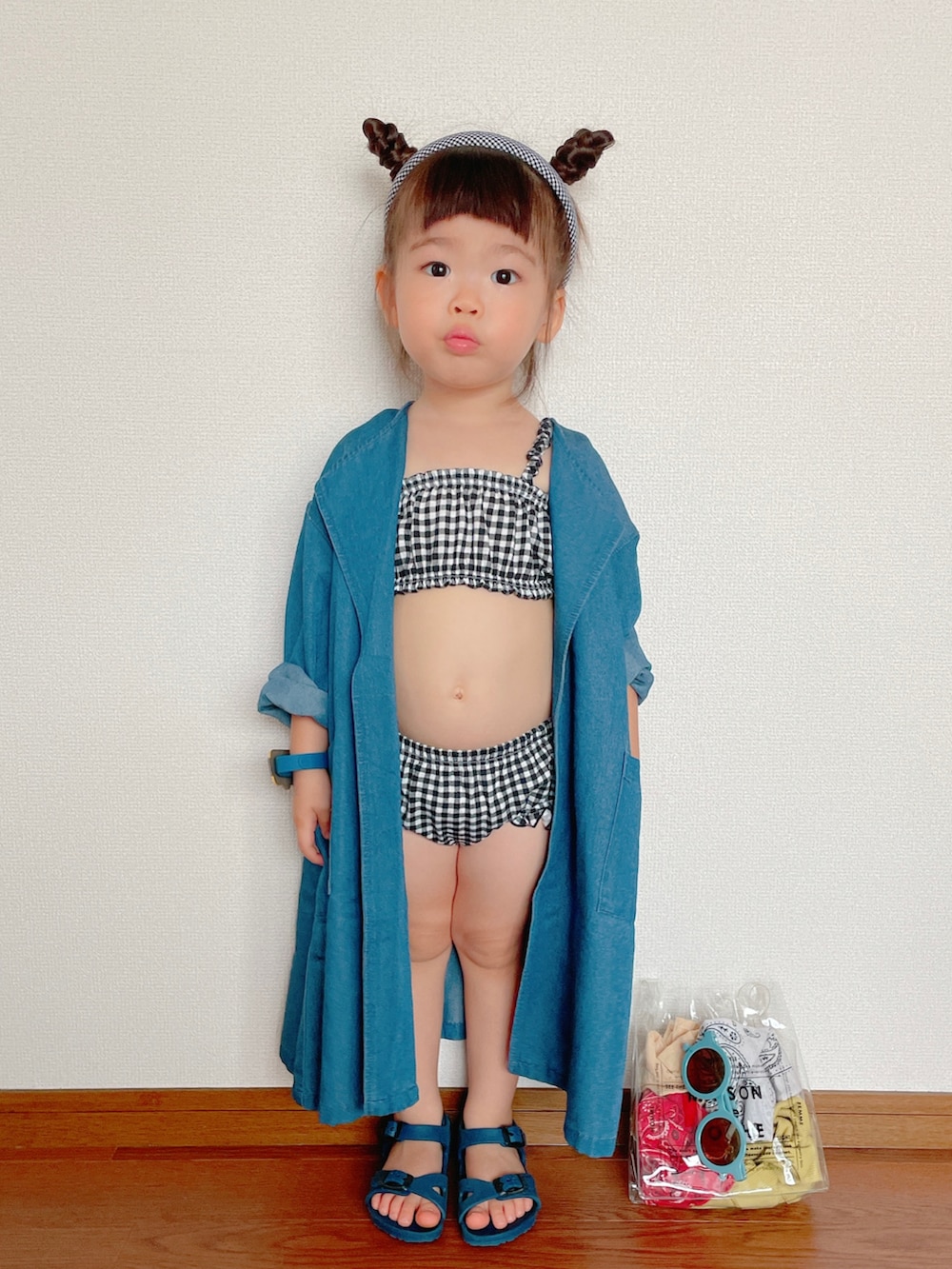 ブルー系のジャケット/アウター、ブルー系のサンダル、ブラック系の水着を着用したキッズの夏コーディネートの2枚目の写真