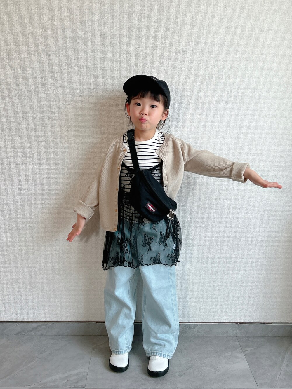 ホワイト系のTシャツ/カットソー、ベージュ系のカーディガン/ボレロ、ブラック系のワンピース/ドレスを着用したキッズの春コーディネートの3枚目の写真