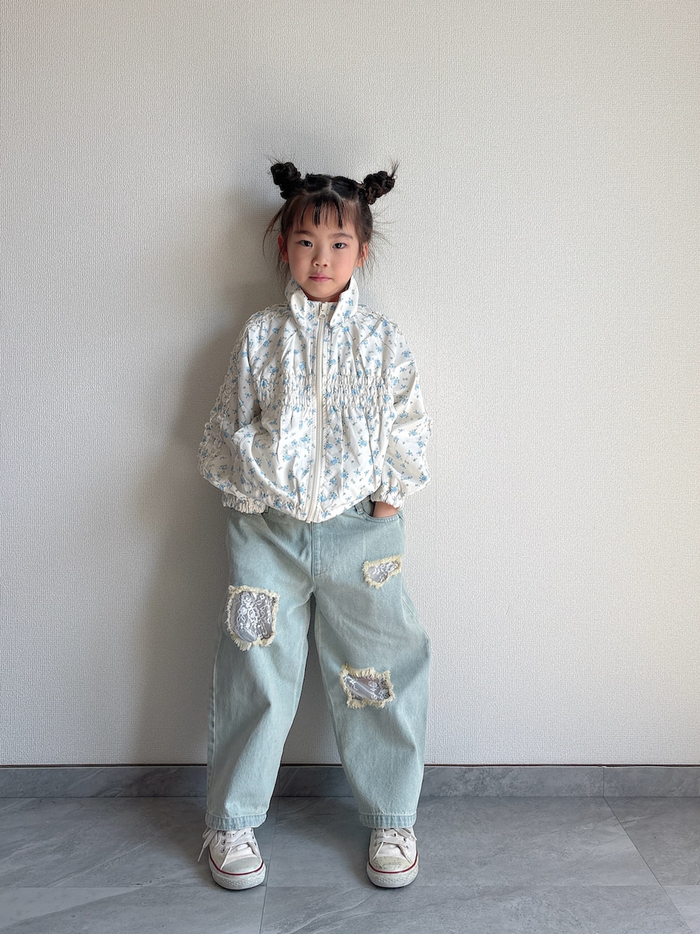 ホワイト系のマウンテンパーカー、ブルー系のデニムパンツを着用したキッズの春コーディネートの5枚目の写真