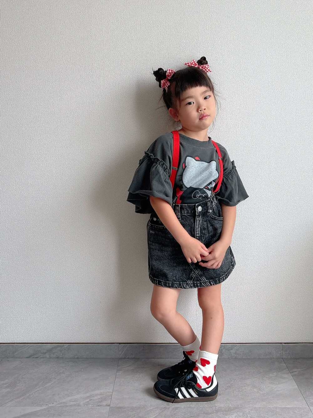 ブラック系のデニムスカート、ブラック系のスニーカー、グレー系のTシャツ/カットソーを着用したキッズの夏コーディネートの2枚目の写真