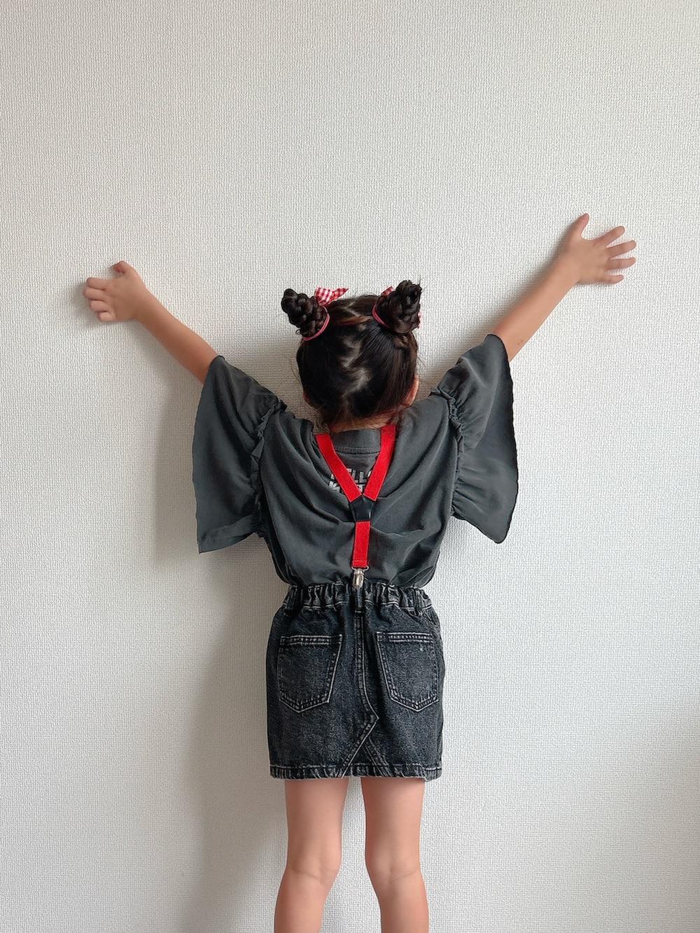 ブラック系のデニムスカート、ブラック系のスニーカー、グレー系のTシャツ/カットソーを着用したキッズの夏コーディネートの5枚目の写真