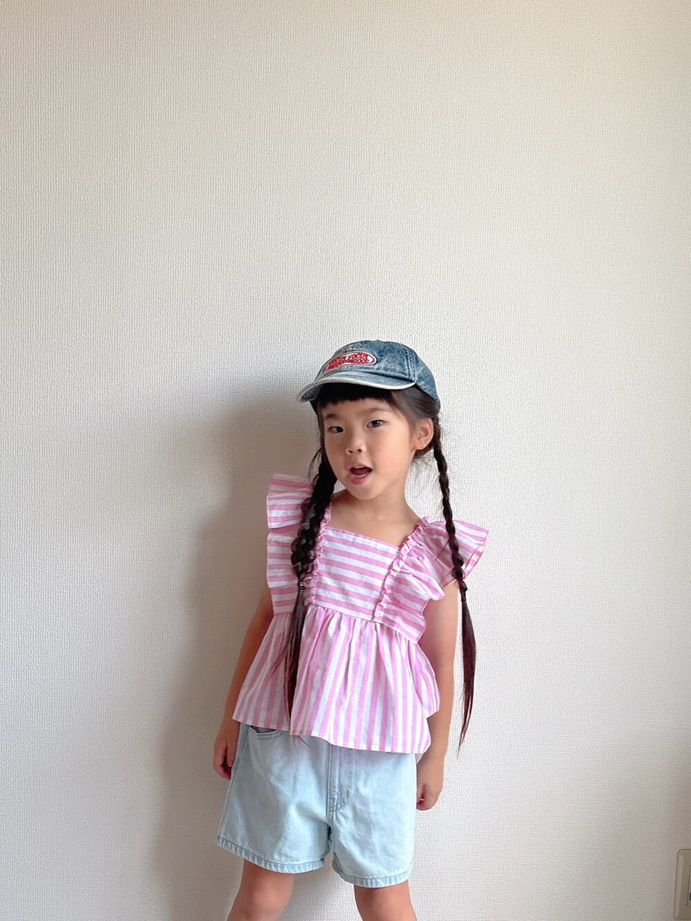 ピンク系のシャツ/ブラウス、ブルー系のデニムパンツ、グレー系のスニーカーを着用したキッズの夏コーディネートの3枚目の写真