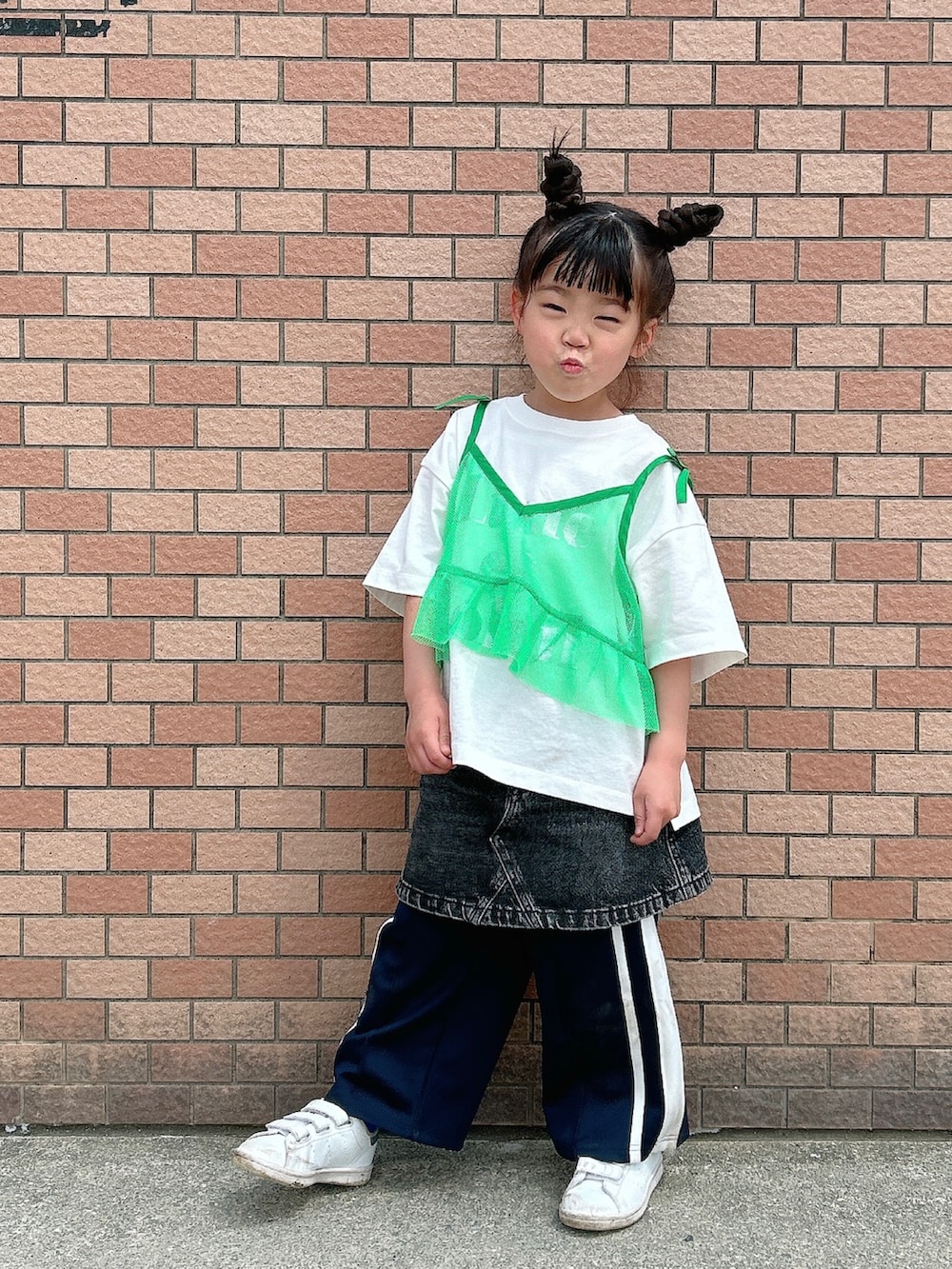 グリーン系のキャミソール、ホワイト系のTシャツ/カットソー、ブラック系のデニムスカートを着用したキッズの春コーディネートの2枚目の写真