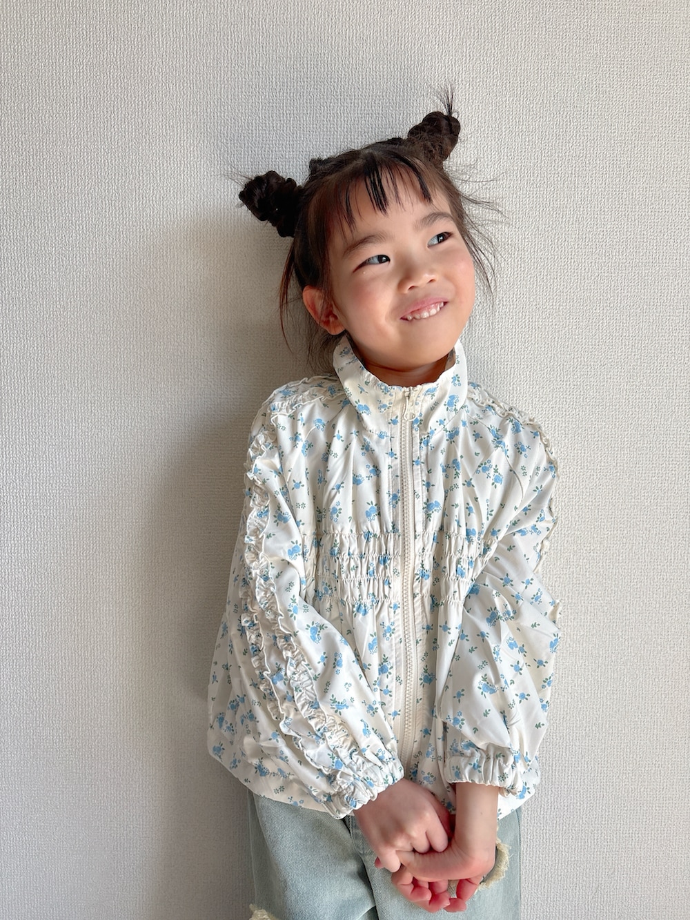 ホワイト系のマウンテンパーカー、ブルー系のデニムパンツを着用したキッズの春コーディネートの3枚目の写真