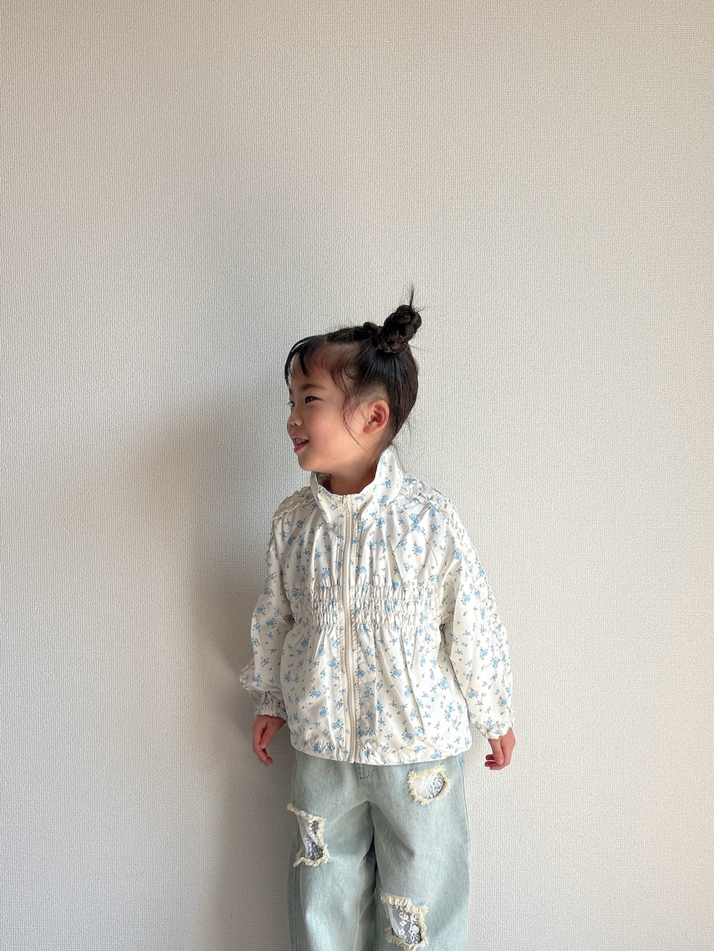 ホワイト系のマウンテンパーカー、ブルー系のデニムパンツを着用したキッズの春コーディネートの4枚目の写真