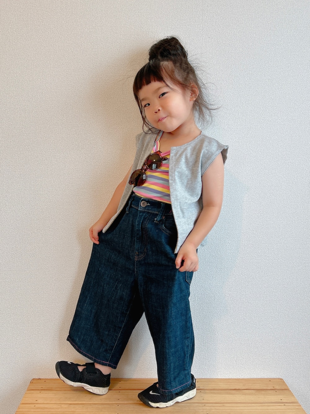 イエロー系のキャミソール、グレー系のベスト、ブルー系のデニムパンツを着用したキッズの夏コーディネートの5枚目の写真