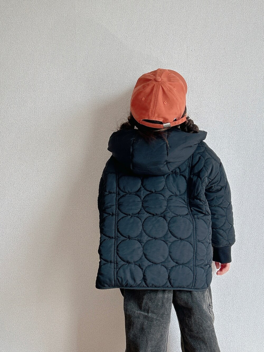 ブラック系のその他アウター、ホワイト系のニット/セーター、ブラック系のデニムパンツを着用したキッズの秋コーディネートの3枚目の写真