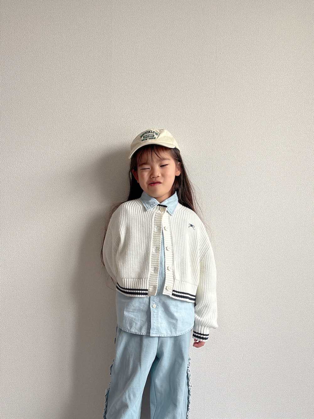 ブルー系のその他パンツ、ホワイト系のカーディガン/ボレロ、ブルー系のシャツ/ブラウスを着用したキッズの冬コーディネートの3枚目の写真