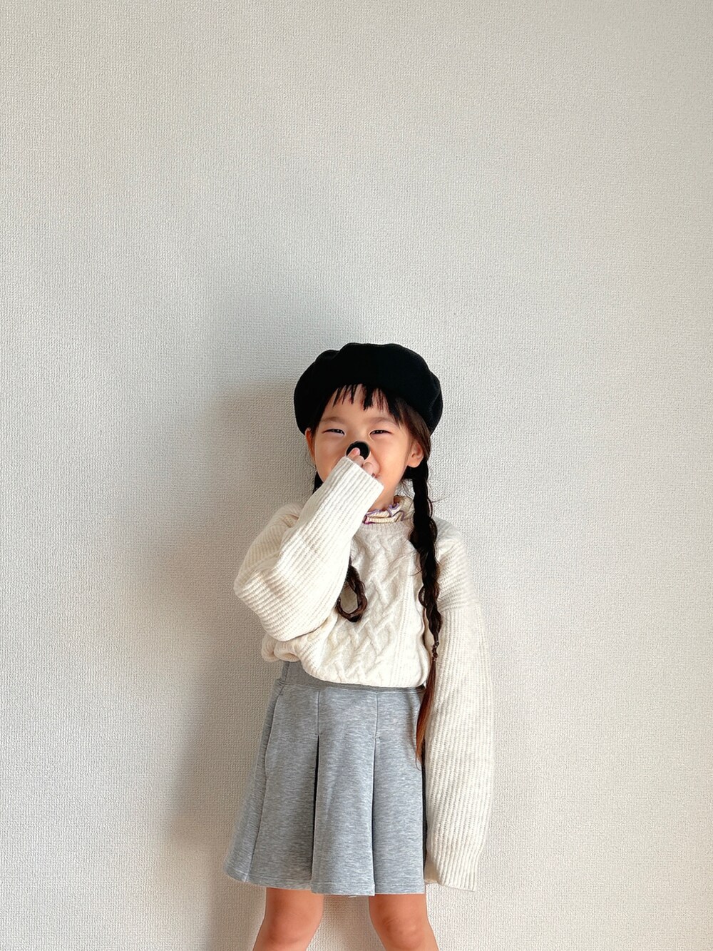 ホワイト系のニット/セーター、グレー系のスカート、ベージュ系のスニーカーを着用したキッズの冬コーディネートの2枚目の写真