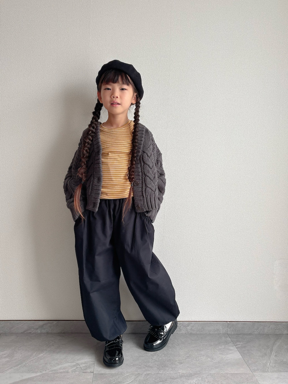 その他のローファー、グレー系のカーディガン/ボレロ、イエロー系のTシャツ/カットソーを着用したキッズの秋コーディネートの2枚目の写真