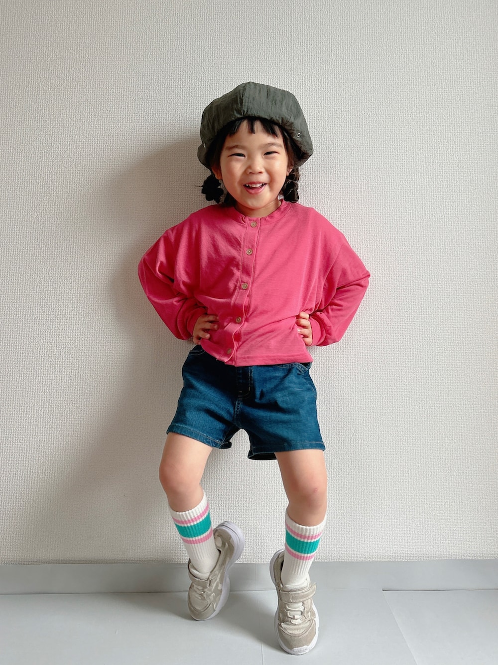 ピンク系のカーディガン/ボレロ、ブルー系のデニムパンツ、ベージュ系のスニーカーを着用したキッズの春コーディネートの3枚目の写真