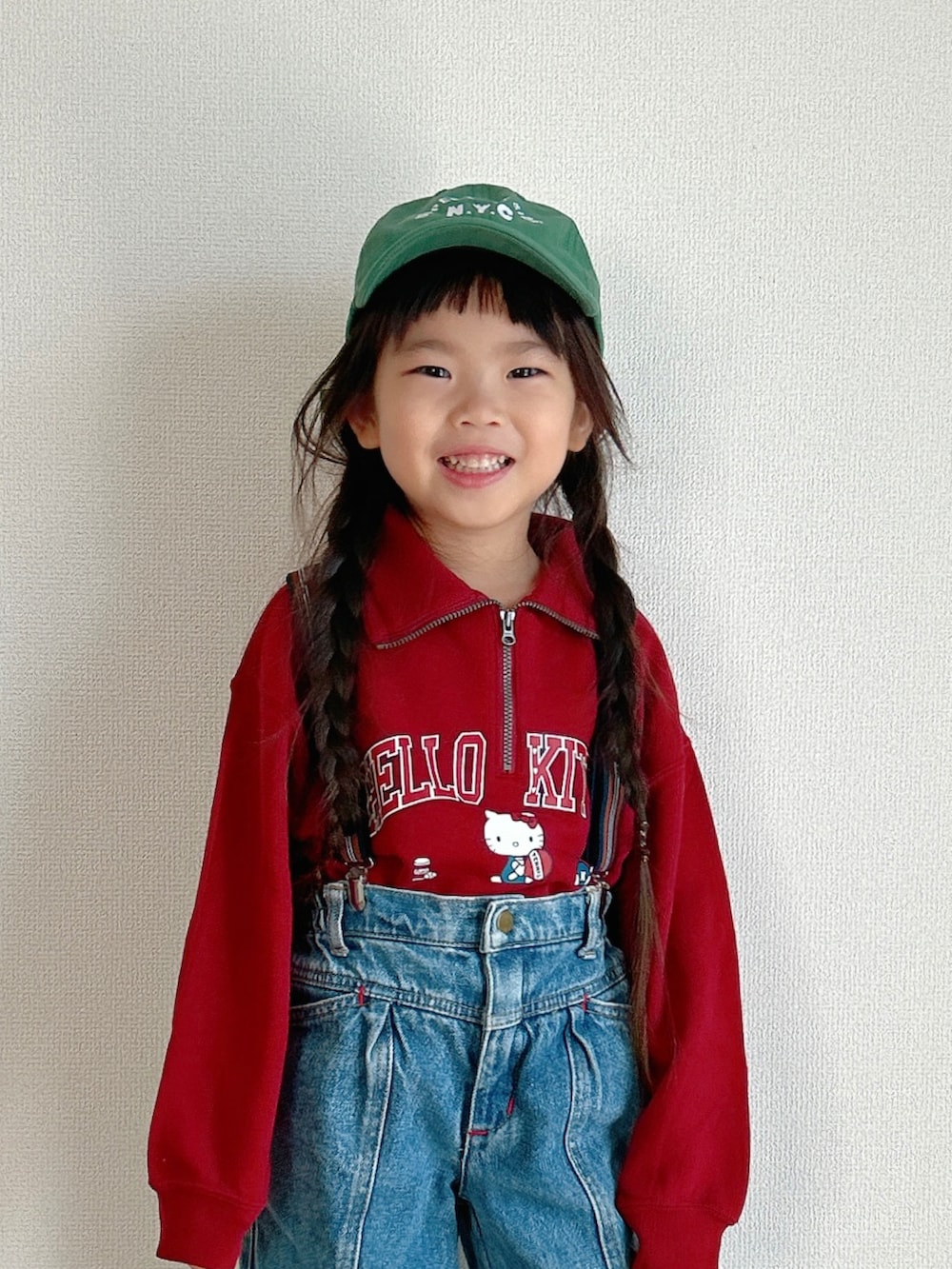 レッド系のスウェット、ブルー系のデニムパンツ、ベージュ系のスニーカーを着用したキッズの秋コーディネートの2枚目の写真