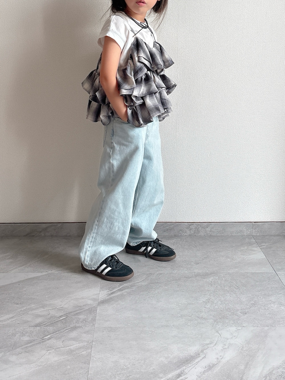 ブラック系のキャミソール、ブルー系のデニムパンツ、ブラック系のスニーカーを着用したキッズの夏コーディネートの4枚目の写真