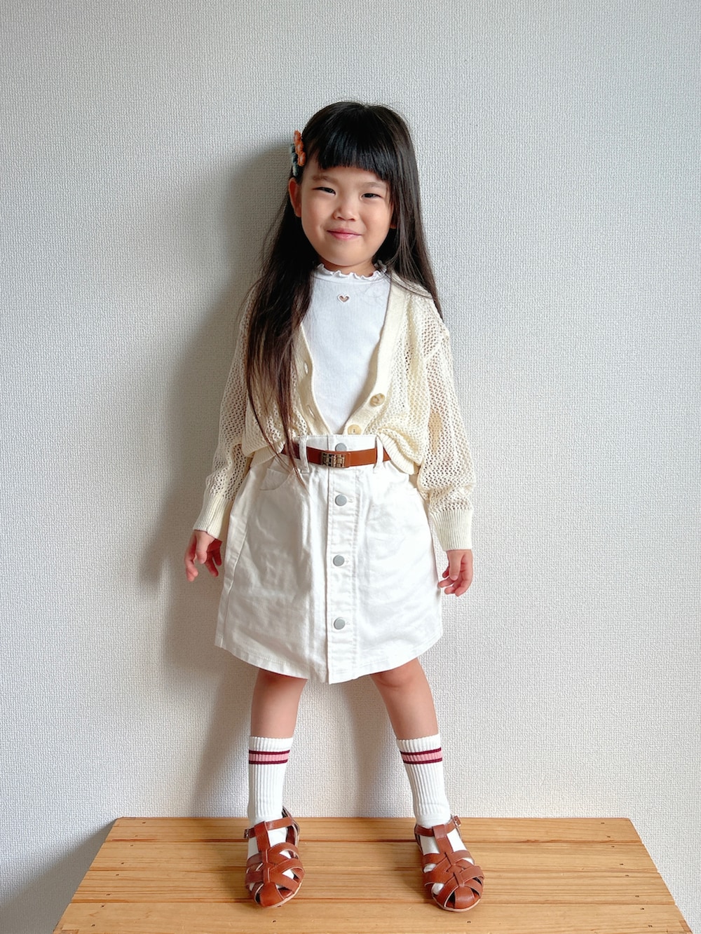 ホワイト系のカーディガン/ボレロ、ホワイト系のTシャツ/カットソー、ホワイト系のデニムスカートを着用したキッズの夏コーディネートの2枚目の写真
