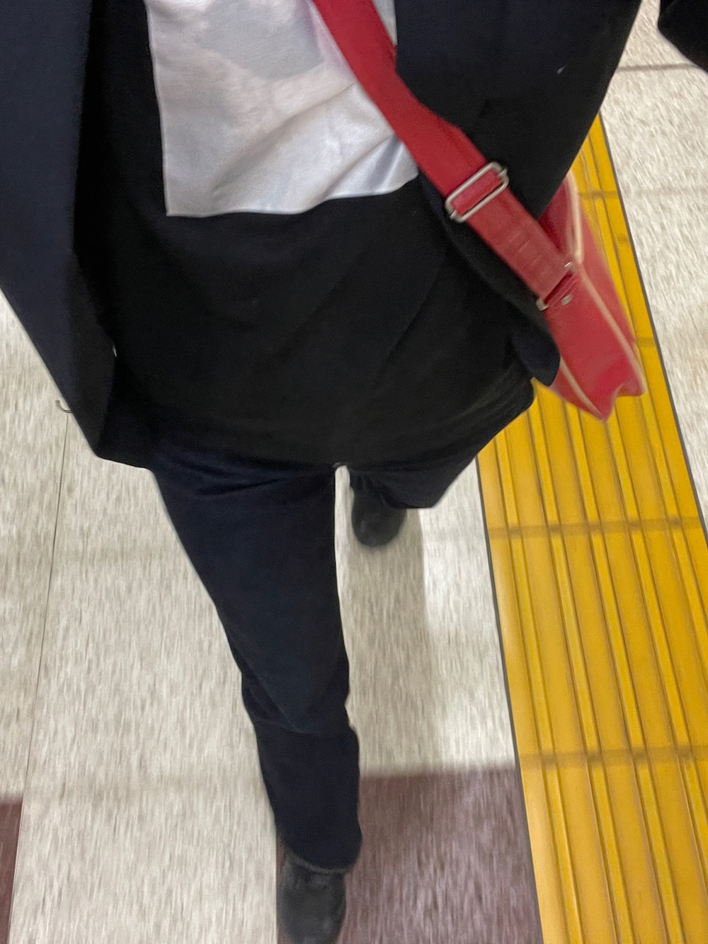 ブラック系のテーラードジャケット、レッド系のショルダーバッグを着用したレディースの秋コーディネートの3枚目の写真