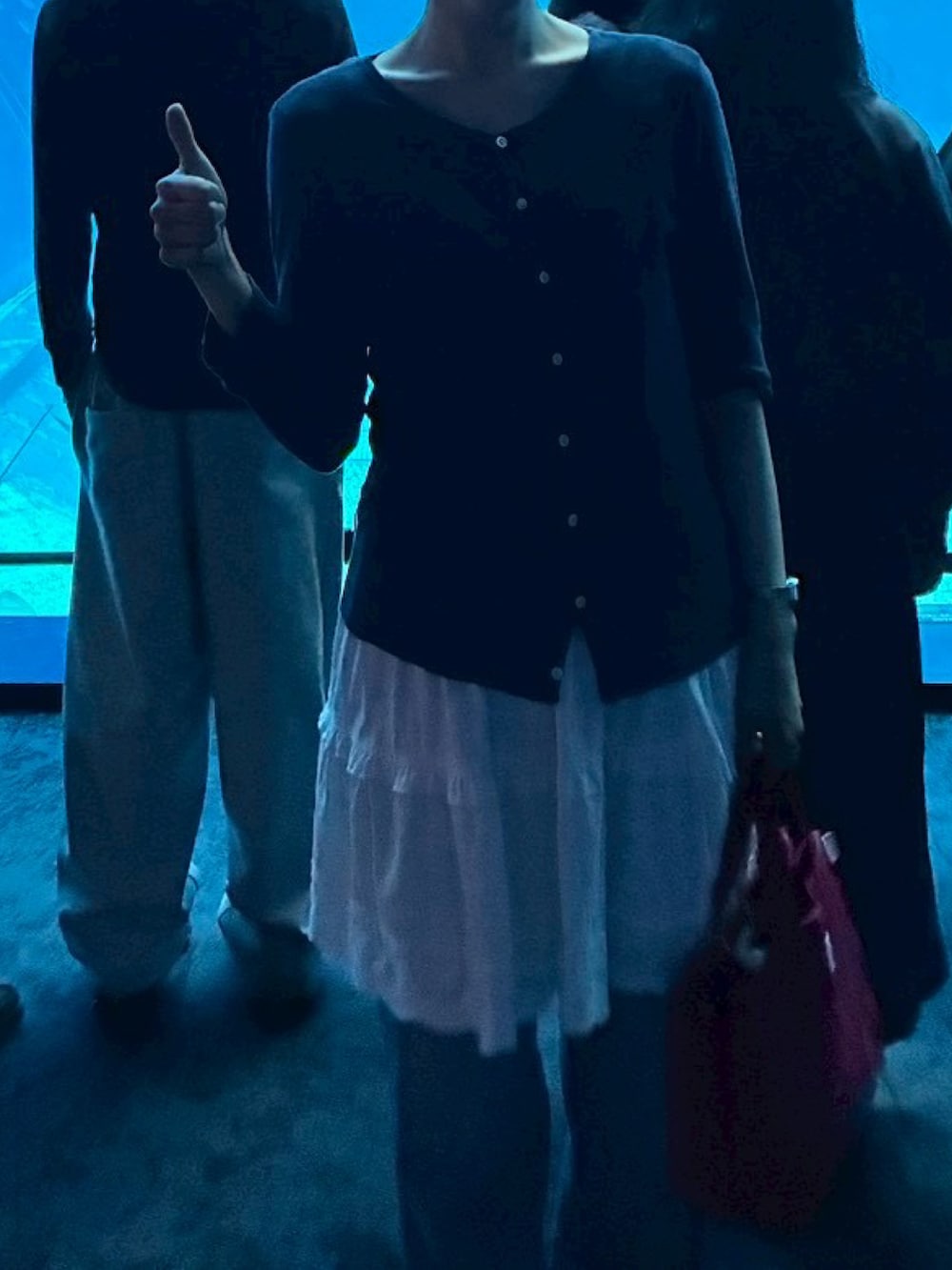 ブルー系のスニーカー、レッド系のハンドバッグを着用したレディースの春コーディネートの2枚目の写真