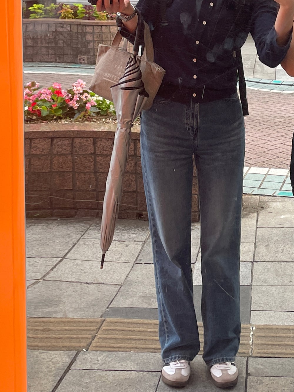 ブルー系のカーディガン/ボレロ、ブルー系のデニムパンツ、ホワイト系のスニーカーを着用したレディースの秋コーディネートの2枚目の写真