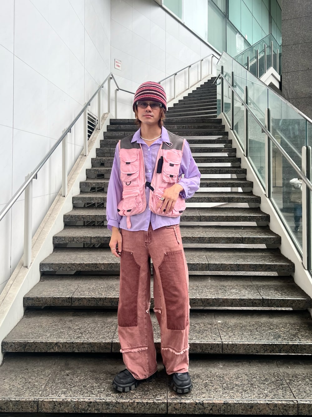 ピンク系のベスト、レッド系のニットキャップ/ビーニーを着用したメンズの秋コーディネートの2枚目の写真