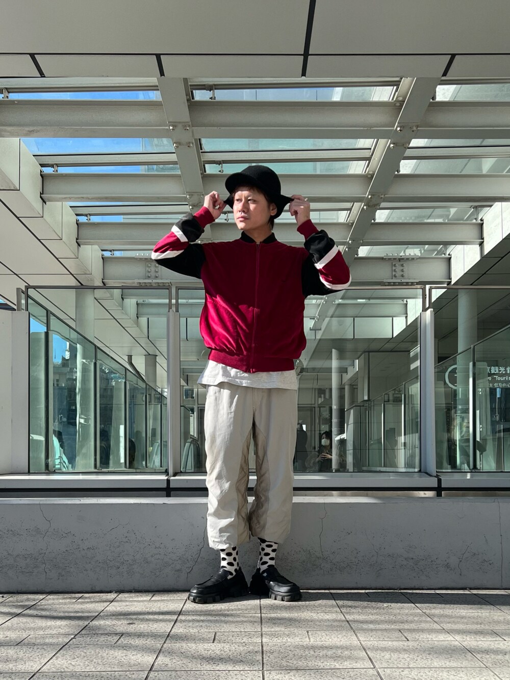レッド系のジャケット/アウター、シルバー系のパンツ、ブラック系のキャップを着用したメンズの冬コーディネートの2枚目の写真
