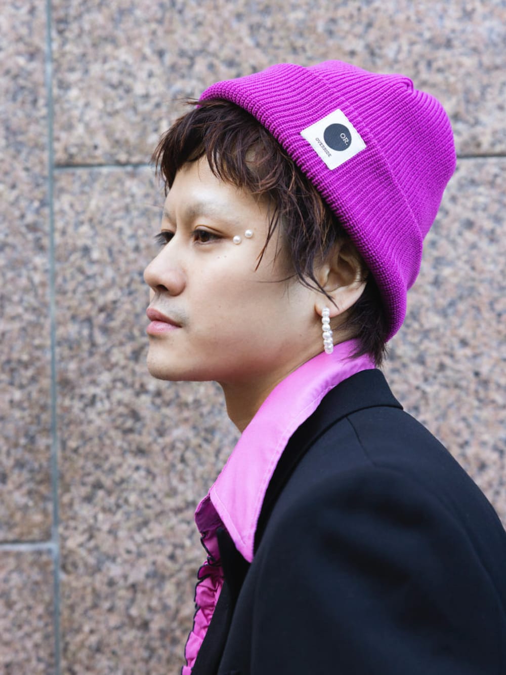 ピンク系のニットキャップ/ビーニーを着用したメンズの春コーディネートの2枚目の写真