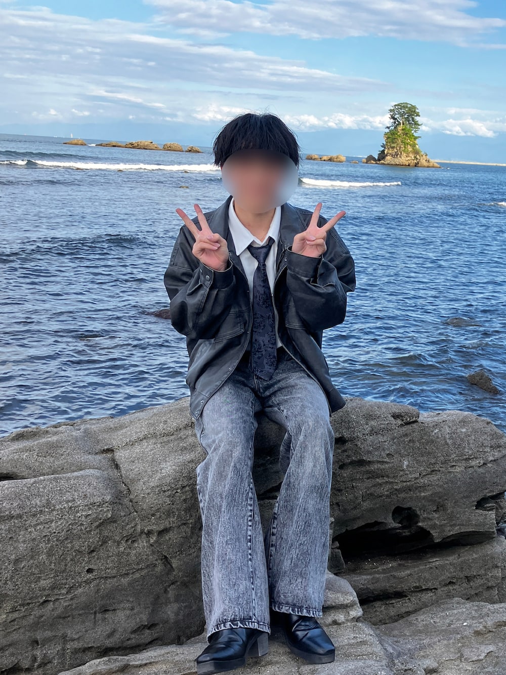 ブラック系のブルゾン、ブラック系のネクタイ、グレー系のデニムパンツを着用したメンズの秋コーディネートの2枚目の写真