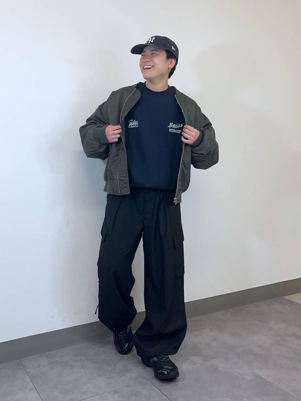 ブラック系のスニーカー、グリーン系のMA-1、ブラック系のスラックスを着用したメンズの冬コーディネートの3枚目の写真