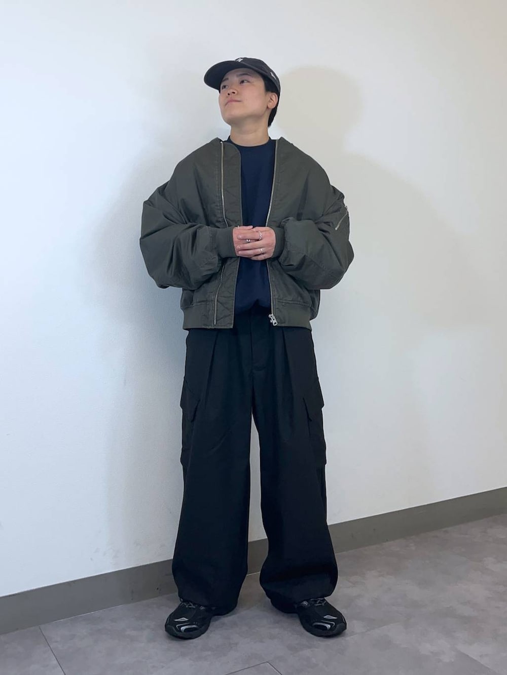 ブラック系のスニーカー、グリーン系のMA-1、ブラック系のスラックスを着用したメンズの冬コーディネートの2枚目の写真