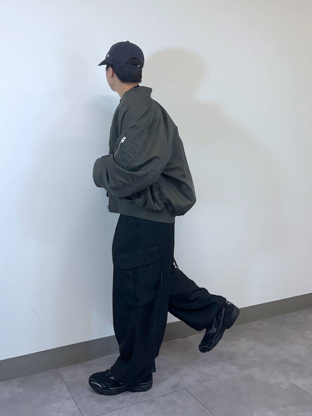 ブラック系のスニーカー、グリーン系のMA-1、ブラック系のスラックスを着用したメンズの冬コーディネートの5枚目の写真