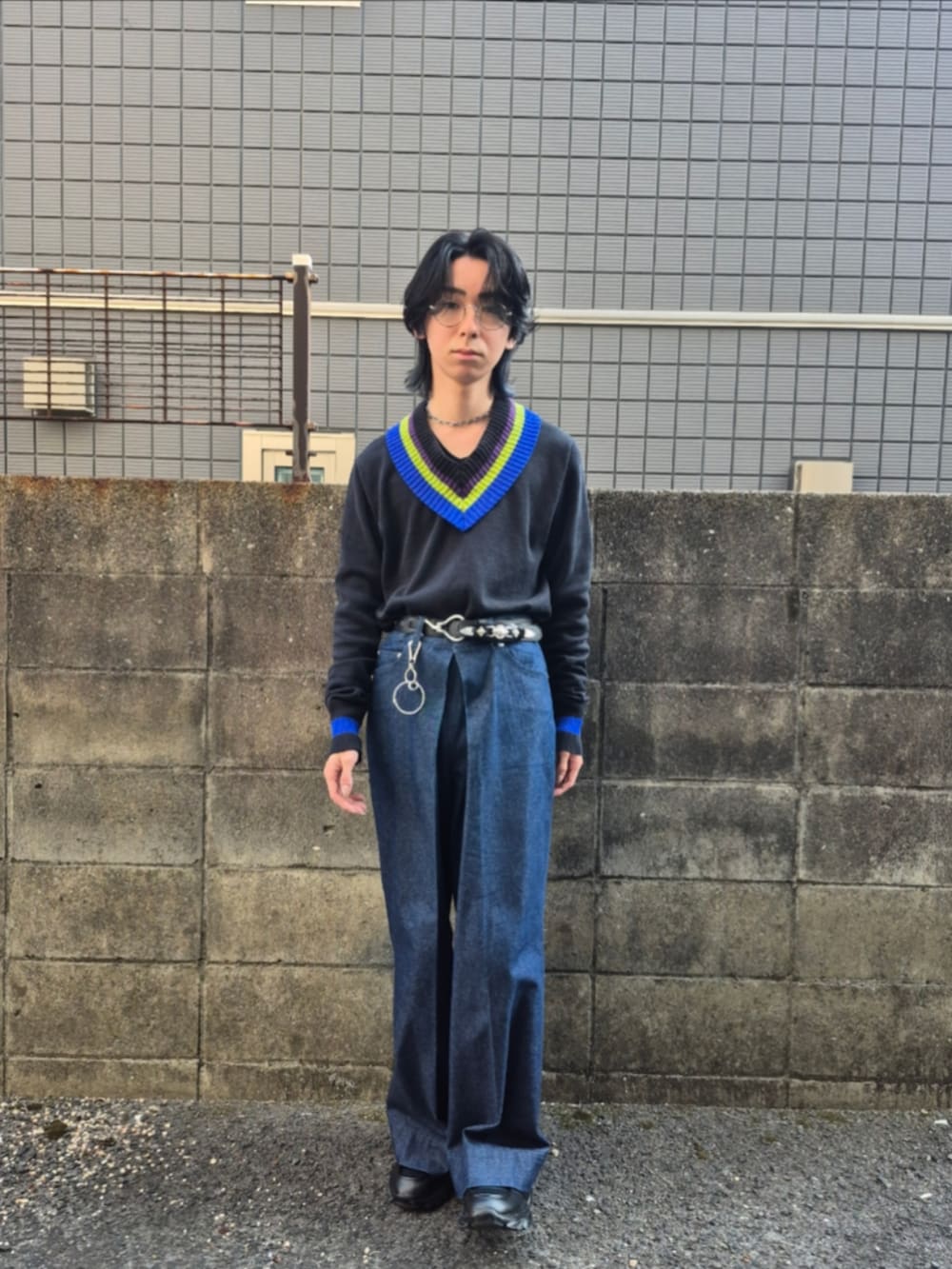 ブラック系のニット/セーター、ブラック系のローファー、ブルー系のデニムパンツを着用したメンズの春コーディネートの2枚目の写真