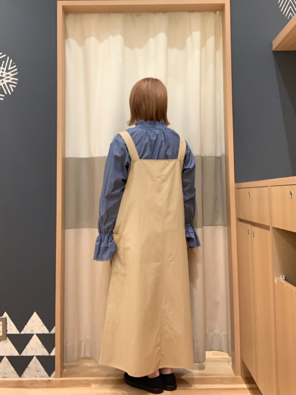 ブラック系のスニーカー、ベージュ系のワンピース、ブルー系のシャツ/ブラウスを着用したレディースの春コーディネートの3枚目の写真