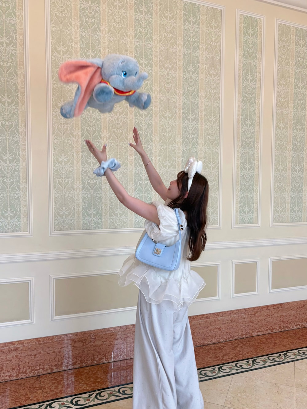 ベージュ系のその他パンツ、ブルー系のハンドバッグ、ホワイト系のパンプスを着用したレディースの夏コーディネートの2枚目の写真