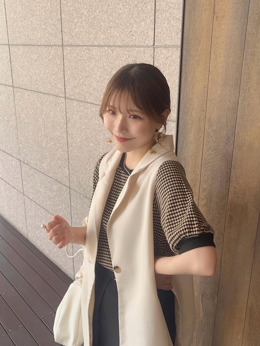 ホワイト系のショルダーバッグ、ブラック系のTシャツ/カットソー、ホワイト系のベストを着用したレディースの夏コーディネートの2枚目の写真