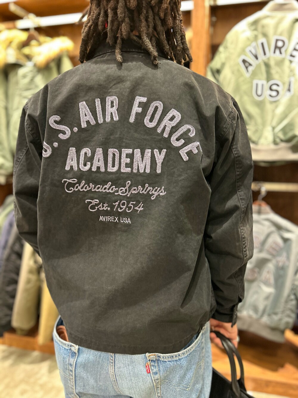 ブラック系のトートバッグ、ホワイト系のTシャツ/カットソーを着用したメンズの冬コーディネートの2枚目の写真